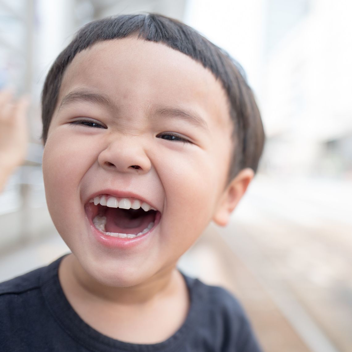 A little boy smiles at the camera.