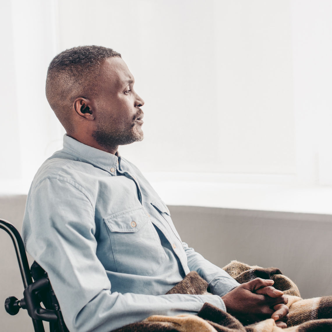 side view of man sitting in wheelchair and looking away