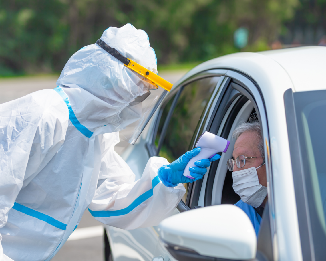 An elderly man gets a drive-through COVID test