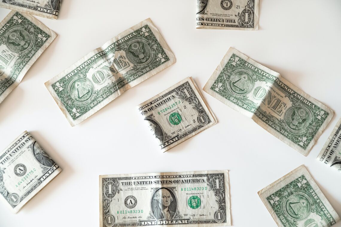 One-dollar bills lie on a table.