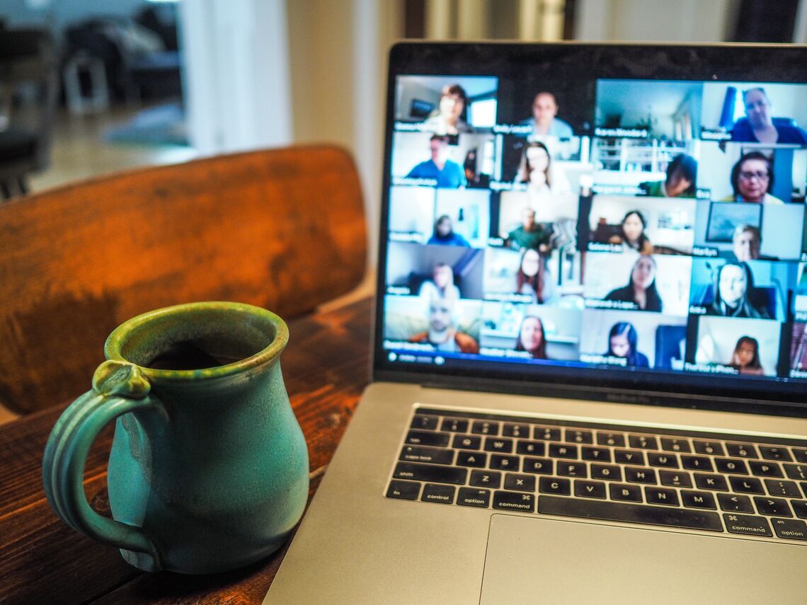 A Zoom meeting on a laptop and a teal mug